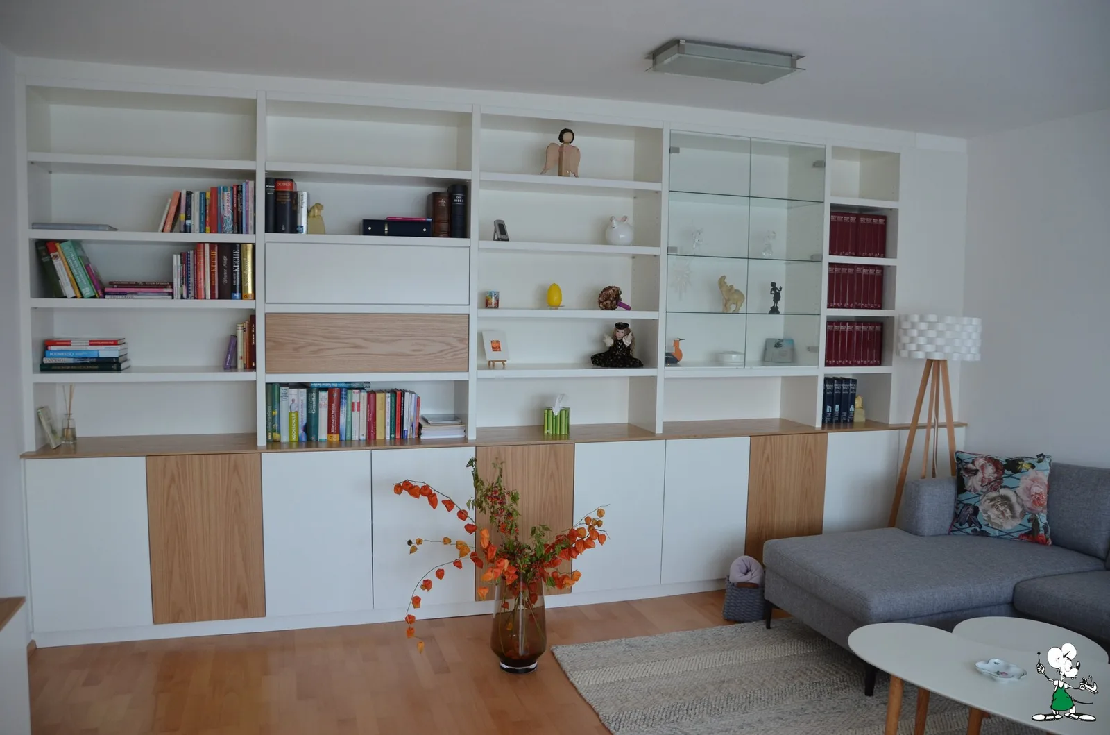 Weiße Regalwand mit Holzfronten in einem Wohnzimmer