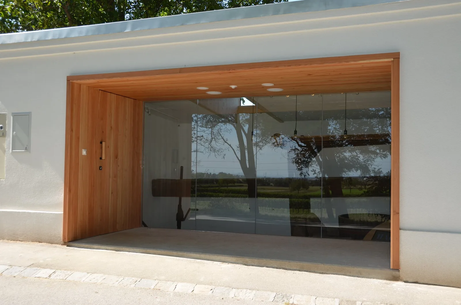 Portal aus Holz mit großer Glasfront in einer Hausmauer