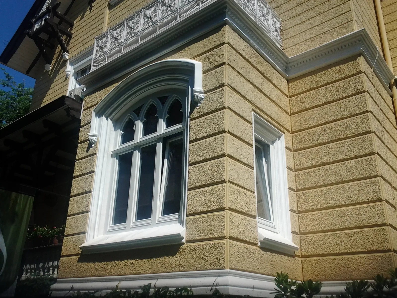Weißes Spitzbogenfenster in einer historischen Fassade